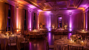 LED uplights creating warm pink and amber atmosphere in a banquet hall